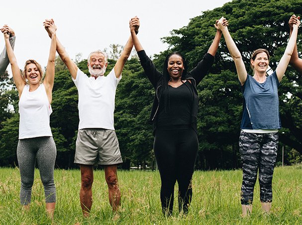 Happy diverse people holding hands in the park